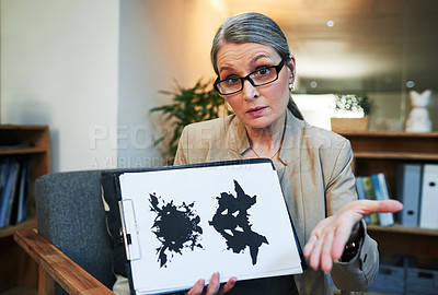 Buy stock photo Portrait of a mature psychologist holding up an inkblot test during a therapeutic session