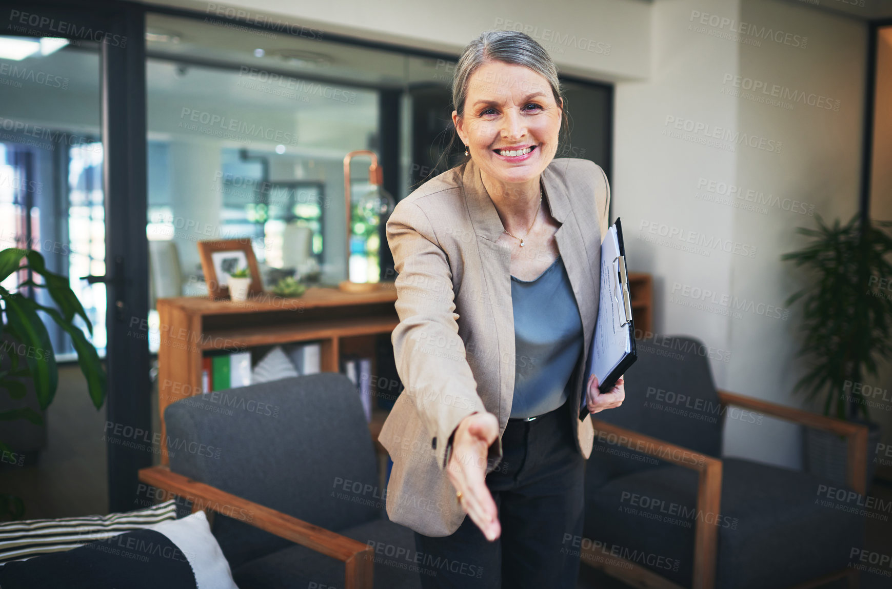 Buy stock photo Portrait of a confident mature psychologist extending her arm for a handshake