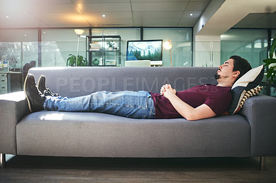 Buy stock photo Shot of a young man lying down on a sofa in a psychologist’s office