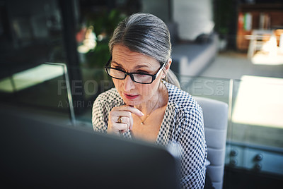 Buy stock photo Shot of a mature businesswoman using a computer in a modern office