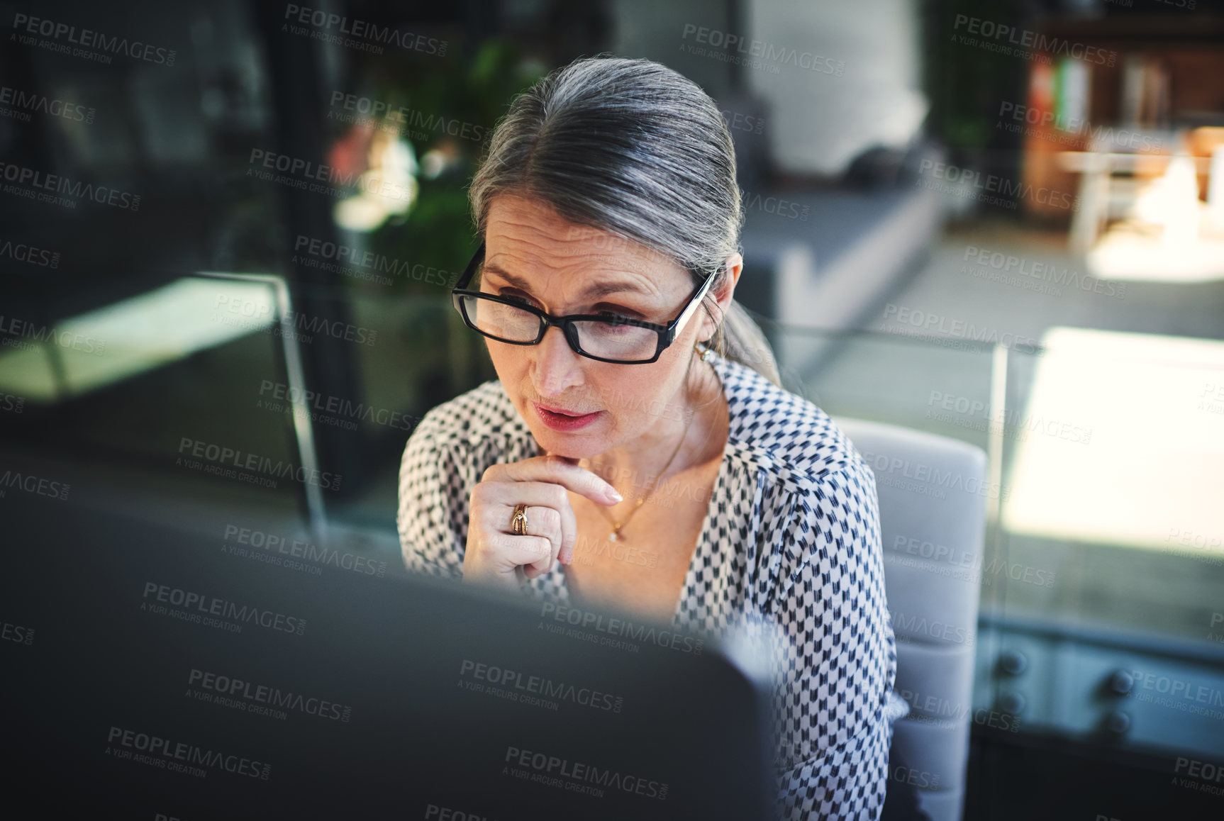 Buy stock photo Shot of a mature businesswoman using a computer in a modern office
