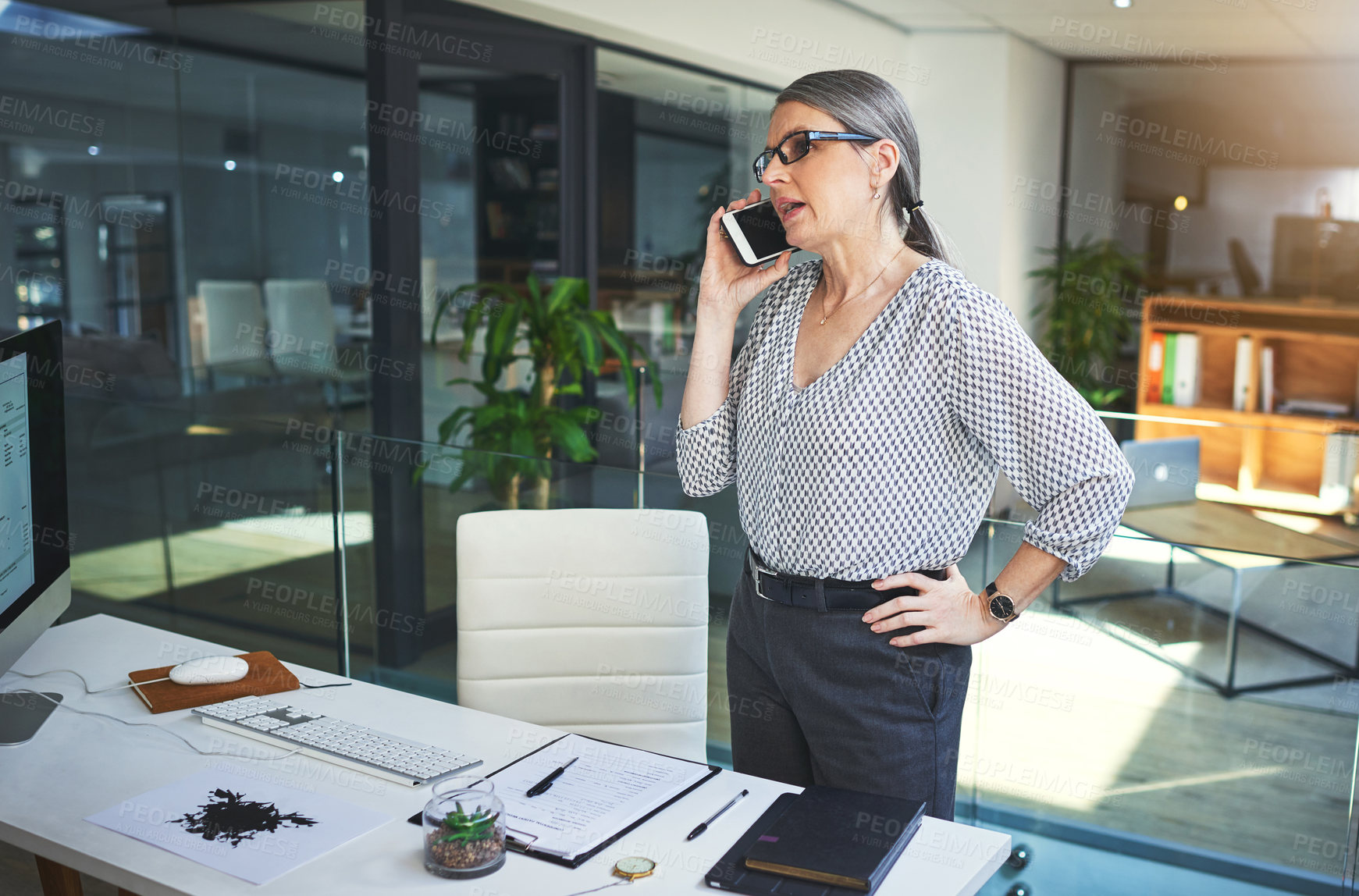 Buy stock photo Shot of a confident mature psychologist using a smartphone in a modern office