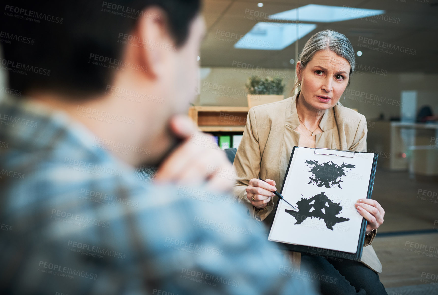 Buy stock photo Shot of a mature psychologist conducting an inkblot test with her patient during a therapeutic session