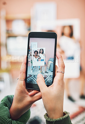 Buy stock photo Shot of two young women posing with a social media prop while having their picture taking on a smartphone