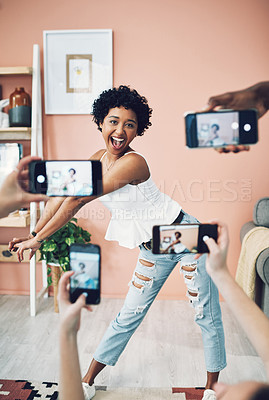 Buy stock photo Shot of a beautiful young woman having her picture taken on multiple phones