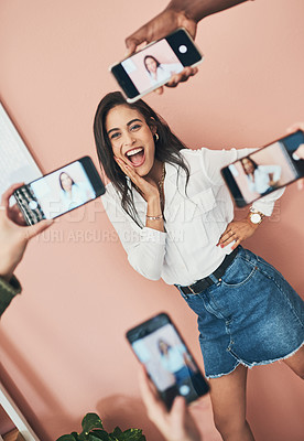 Buy stock photo Shot of a beautiful young woman having her picture taken on multiple phones