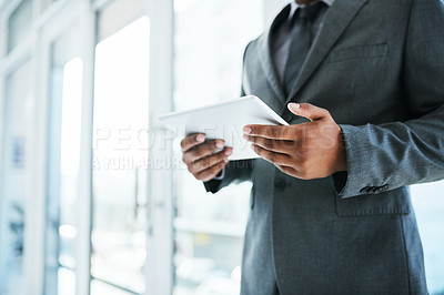 Buy stock photo Shot of a businessman using a digital tablet in a modern office
