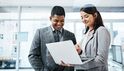 Buy stock photo Shot of a young businessman and businesswoman using a laptop in a modern office