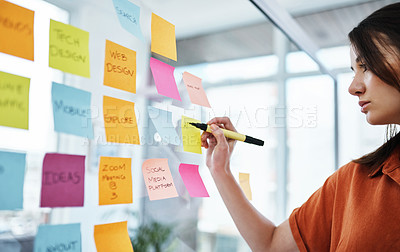 Buy stock photo Woman writing notes, brainstorming with ideas on glass board and sticky note, planning in office with focus. Creative project, agenda and female employee working, strategy and storyboard with goals