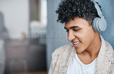 Buy stock photo Shot of a young man using headphones at home