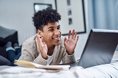 Buy stock photo Shot of a young man using a laptop to have a video call at home