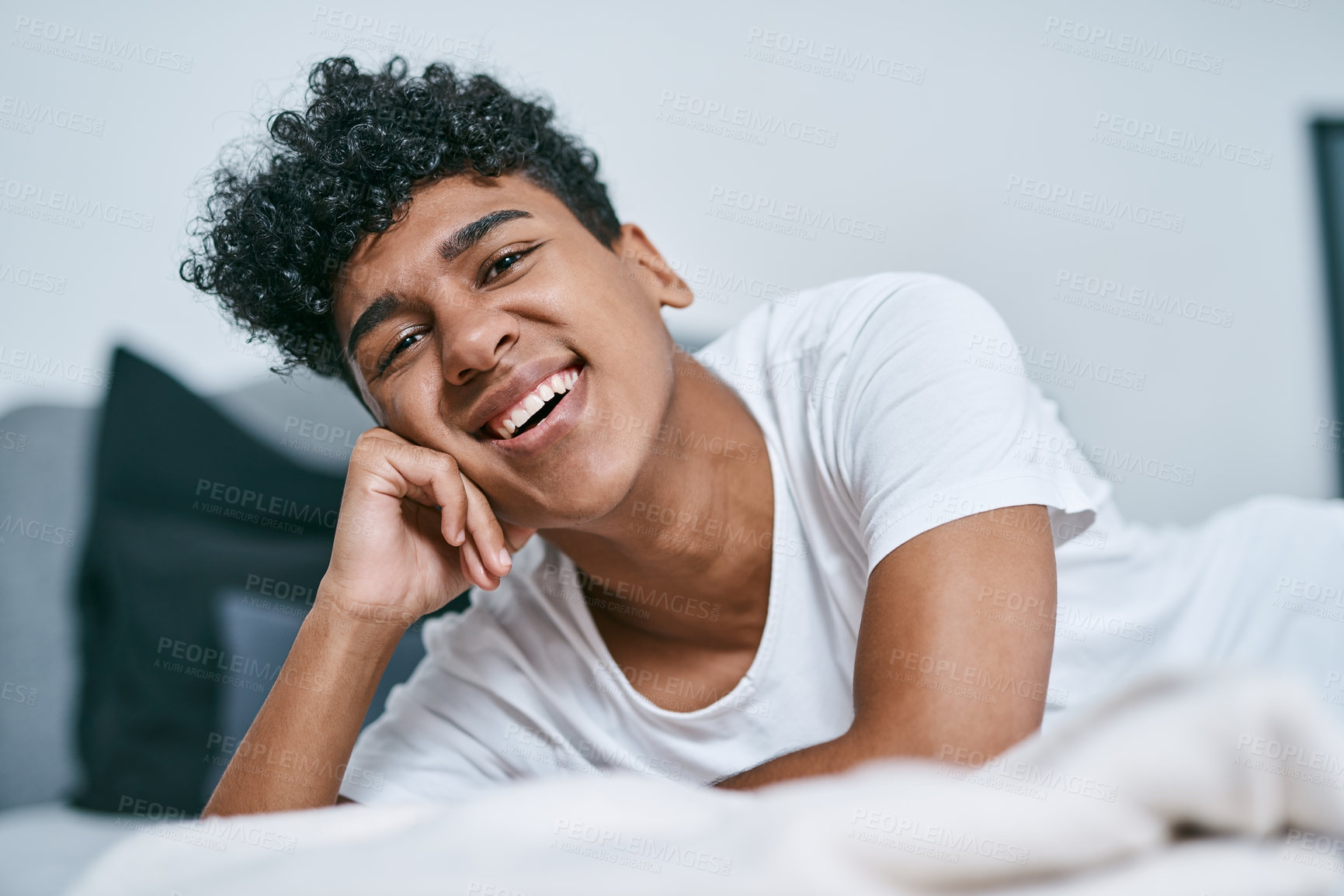 Buy stock photo Boy, portrait and happy on bed in home for relax, comfort and weekend with positive mood, peace or cozy. Teenager, face and chilling in bedroom at morning for break, calm and cheerful with leisure