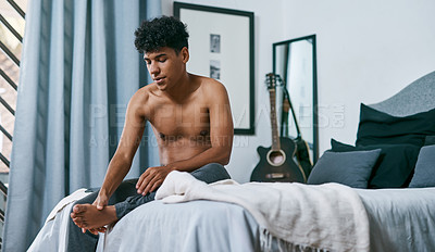 Buy stock photo Shot of a young man waking up with foot pain at home