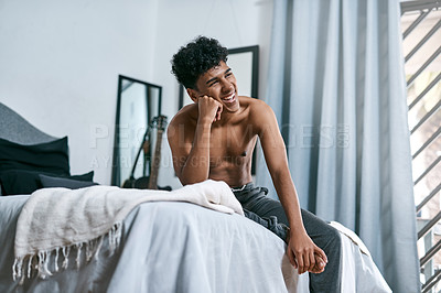 Buy stock photo Shot of a young man relaxing on his bed at home