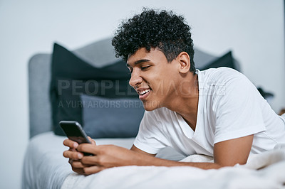 Buy stock photo Teenager, happy and relax on bed with mobile for social media app, online connection and weekend break. Male person, smile and comfort in home with phone conversation for internet, web and streaming