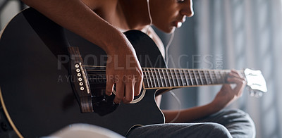 Buy stock photo Cropped shot of a young man playing the guitar in his bedroom at home