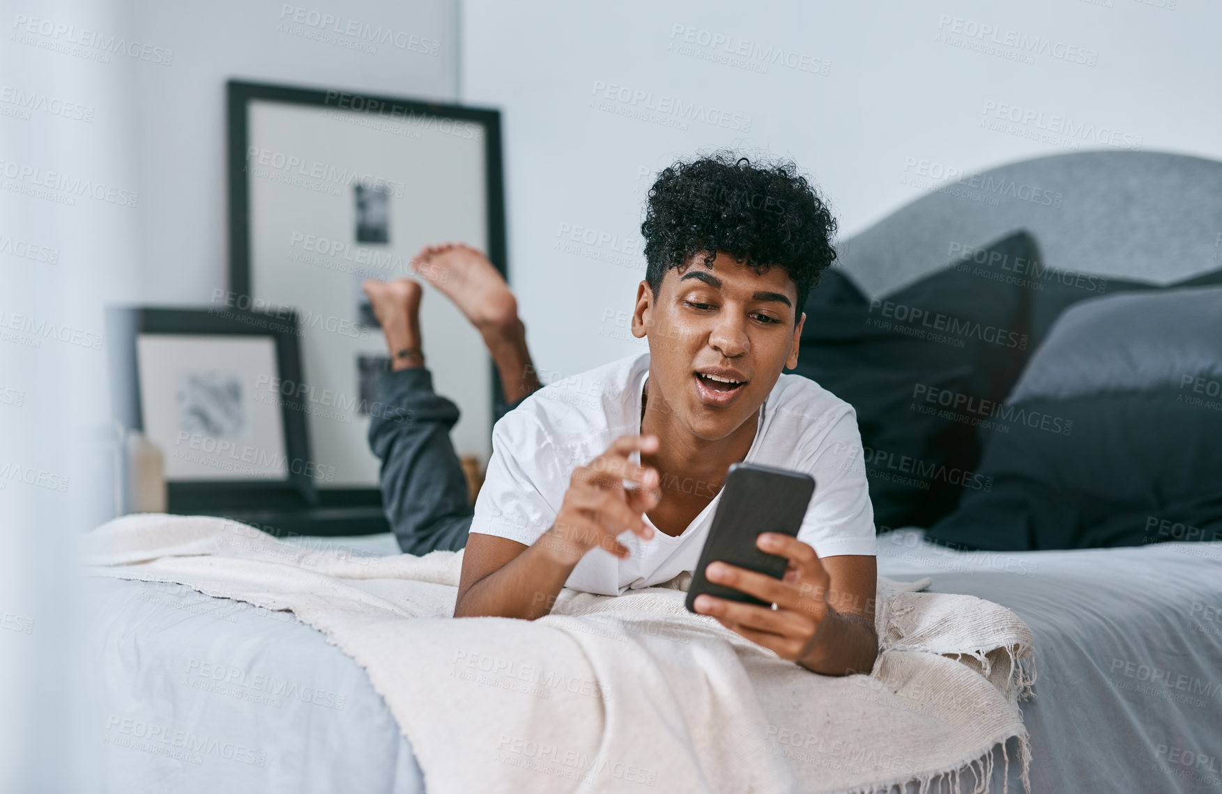 Buy stock photo Teenager, happy and video call on bed with phone for social media app, communication and weekend break. Male person, smile and talking in home with mobile conversation for internet, web and streaming