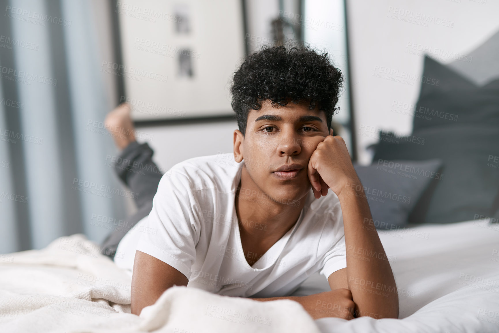 Buy stock photo Boy, portrait and relax on bed in home for bored, comfort and weekend break with fatigue, rest or cozy. Teenager, face and leisure in bedroom at morning for waiting, calm and tired as lazy person