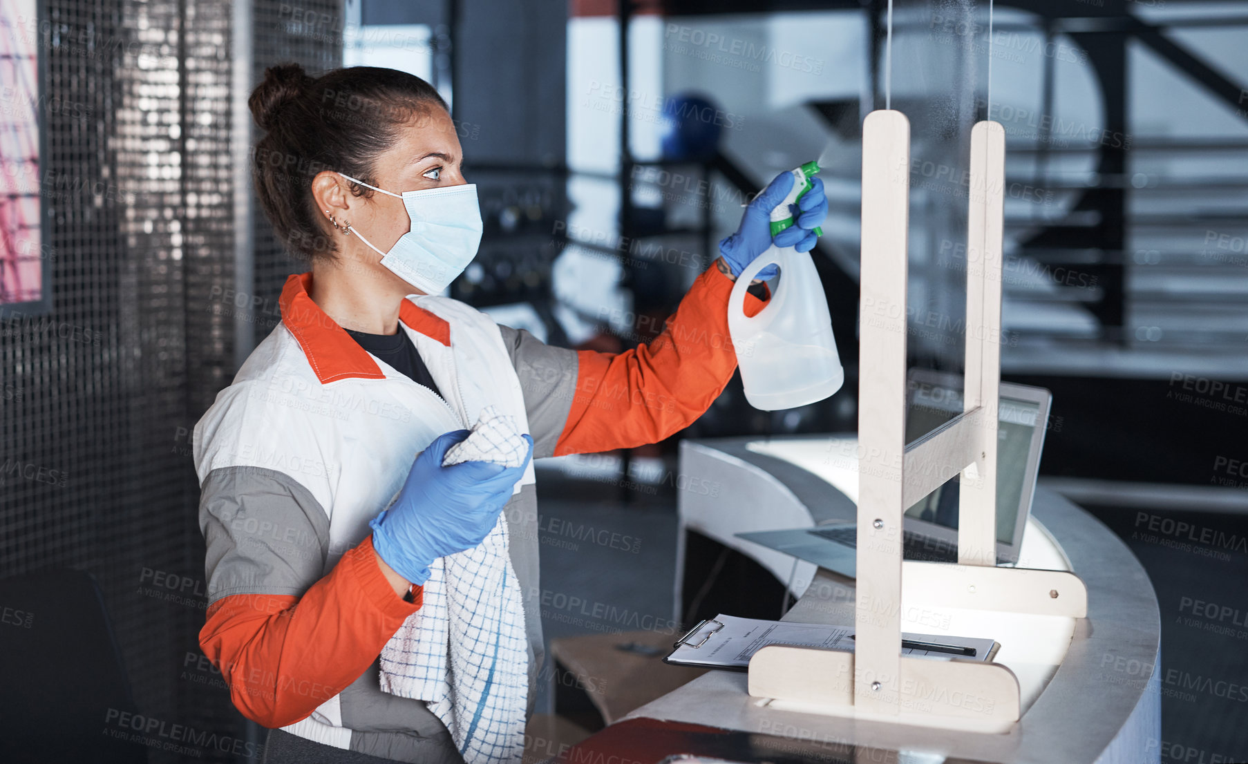 Buy stock photo Shot of a young woman cleaning the reception desk in a gym