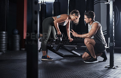 Buy stock photo Shot of a sporty young woman exercising with a fitness instructor in a gym
