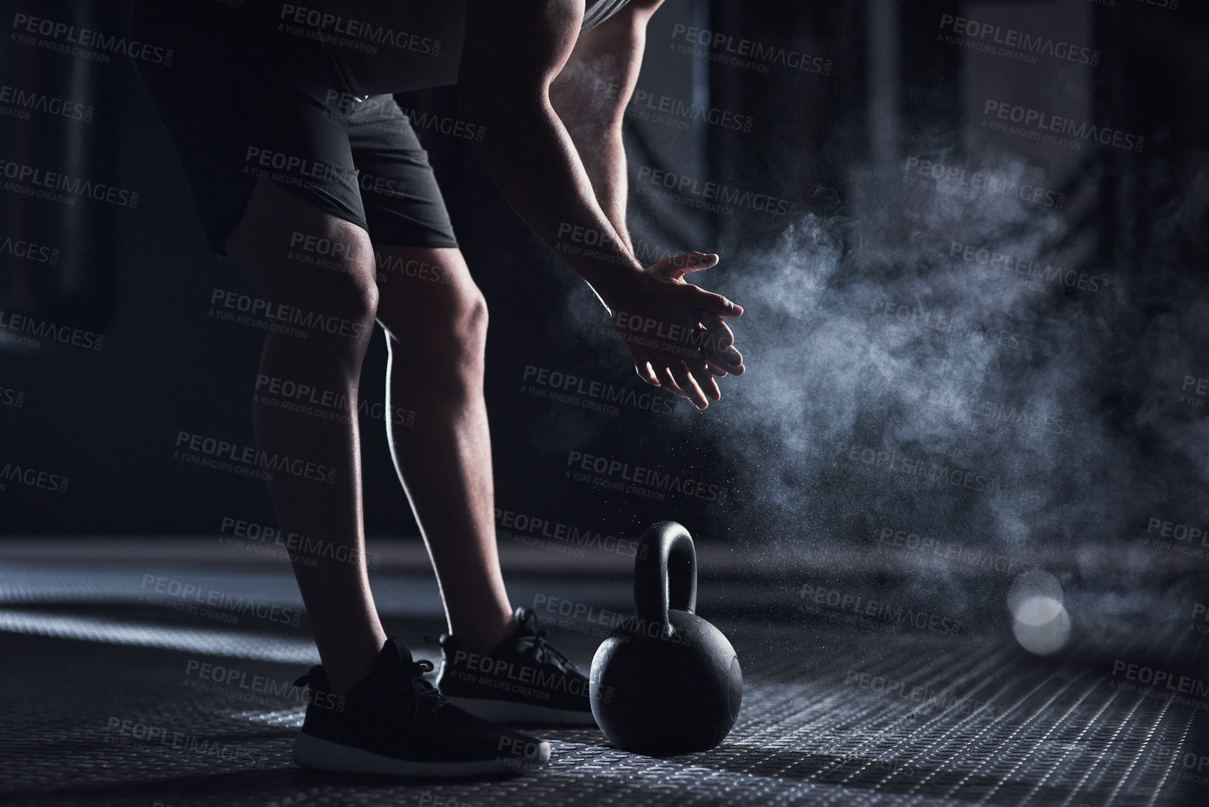Buy stock photo Closeup shot of an unrecognisable man rubbing sports chalk on his hands while exercising with a kettlebell in a gym