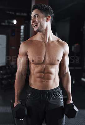 Buy stock photo Cropped shot of a handsome and buff young man working out with dumbbells while shirtless in the gym
