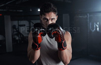 Buy stock photo Portrait of a young man practicing his boxing routine at a gym