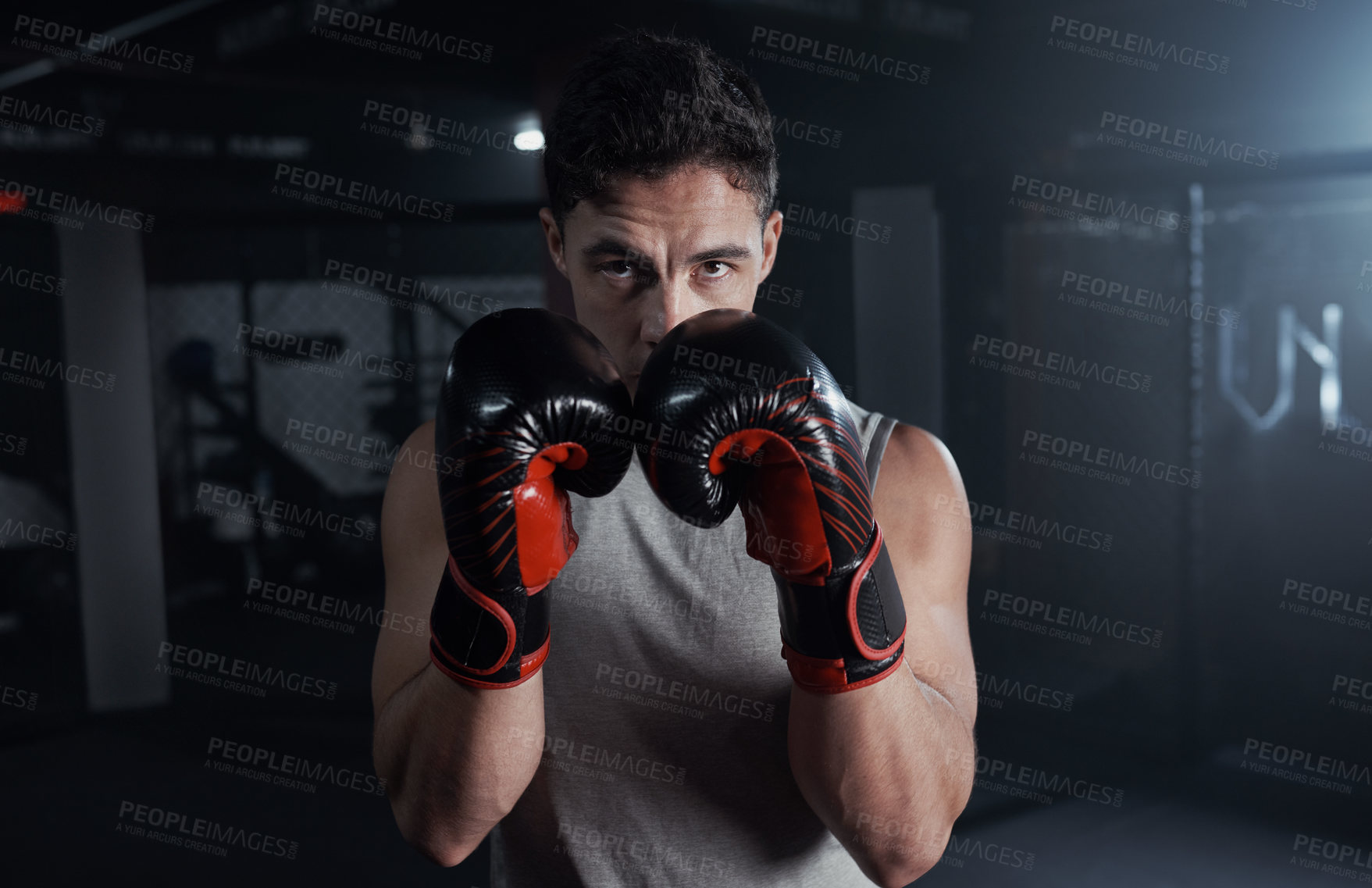 Buy stock photo Portrait of a young man practicing his boxing routine at a gym
