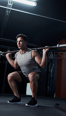 Buy stock photo Shot of a young man lifting a steel pole during his workout at a gym