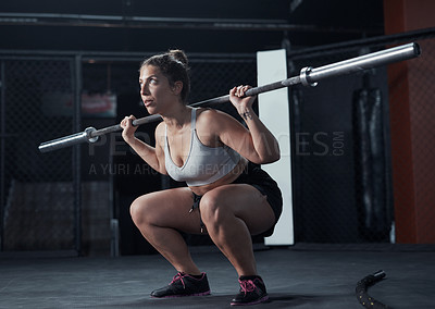 Buy stock photo Shot of a young woman lifting a steel pole during her workout at a gym