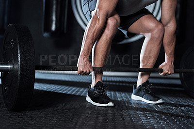 Buy stock photo Shot of an unrecognisable man lifting a barbell during his workout at a gym