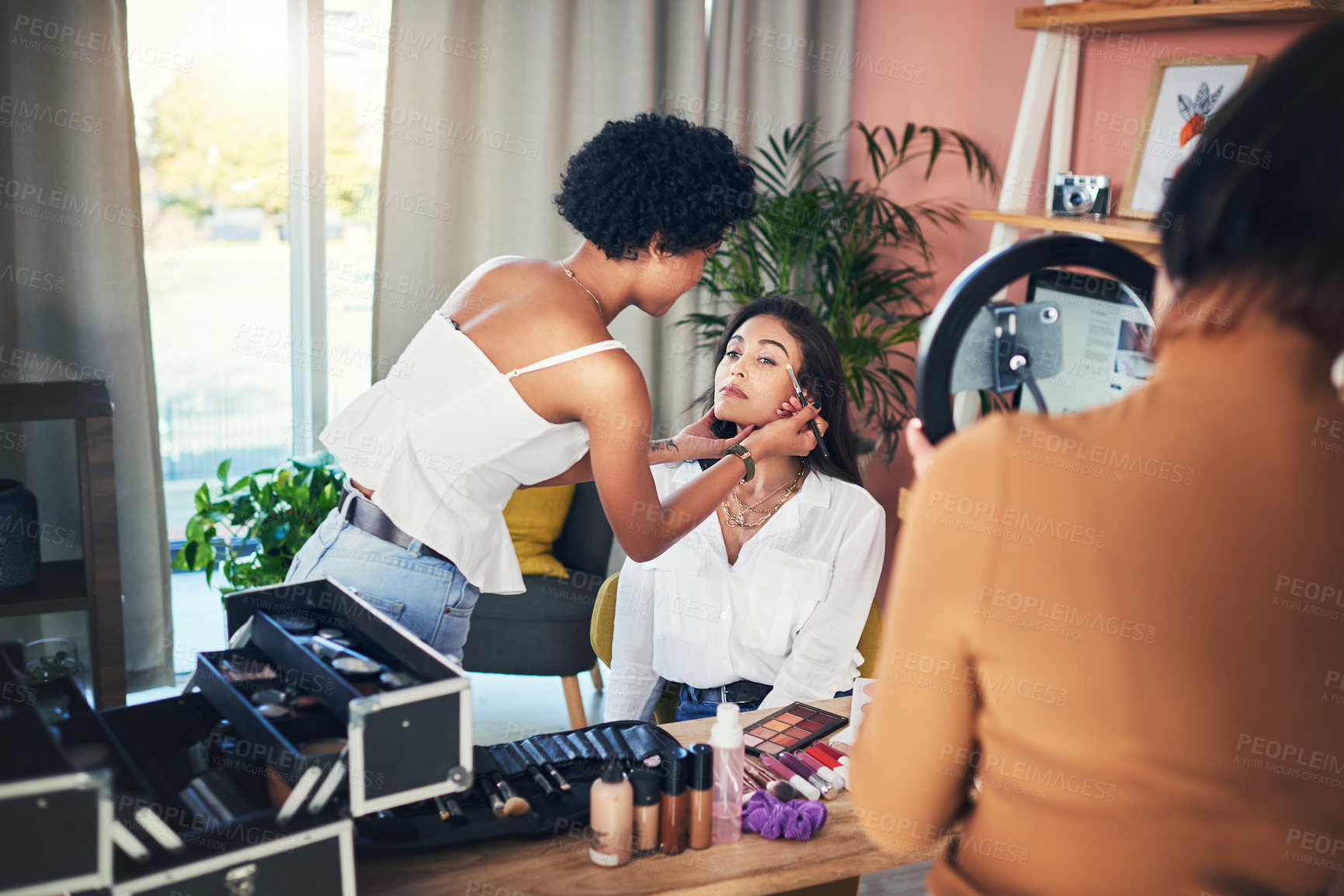 Buy stock photo Shot of a woman getting her makeup done while being recorded