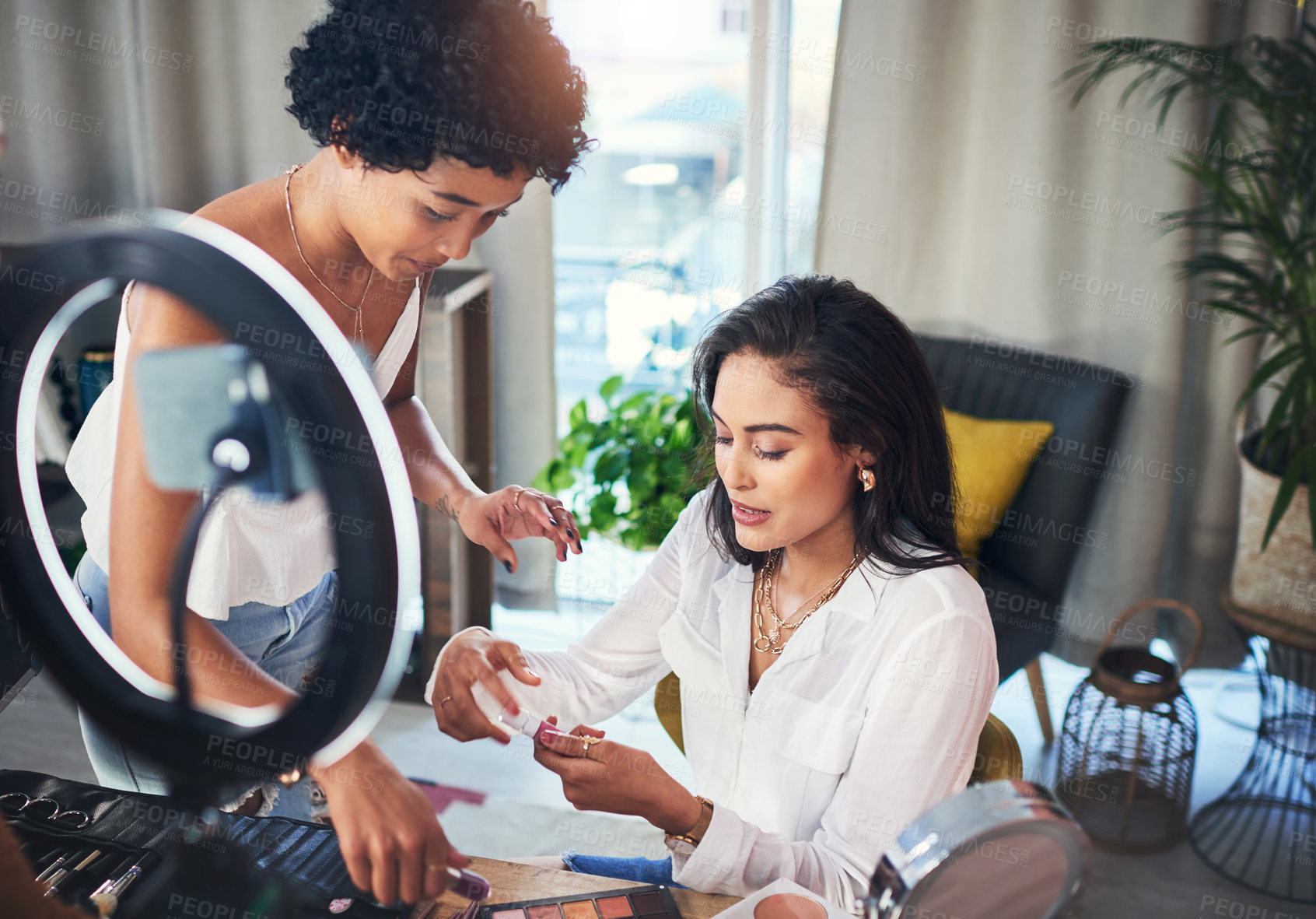 Buy stock photo Shot of two women doing a makeup tutorial for their blog