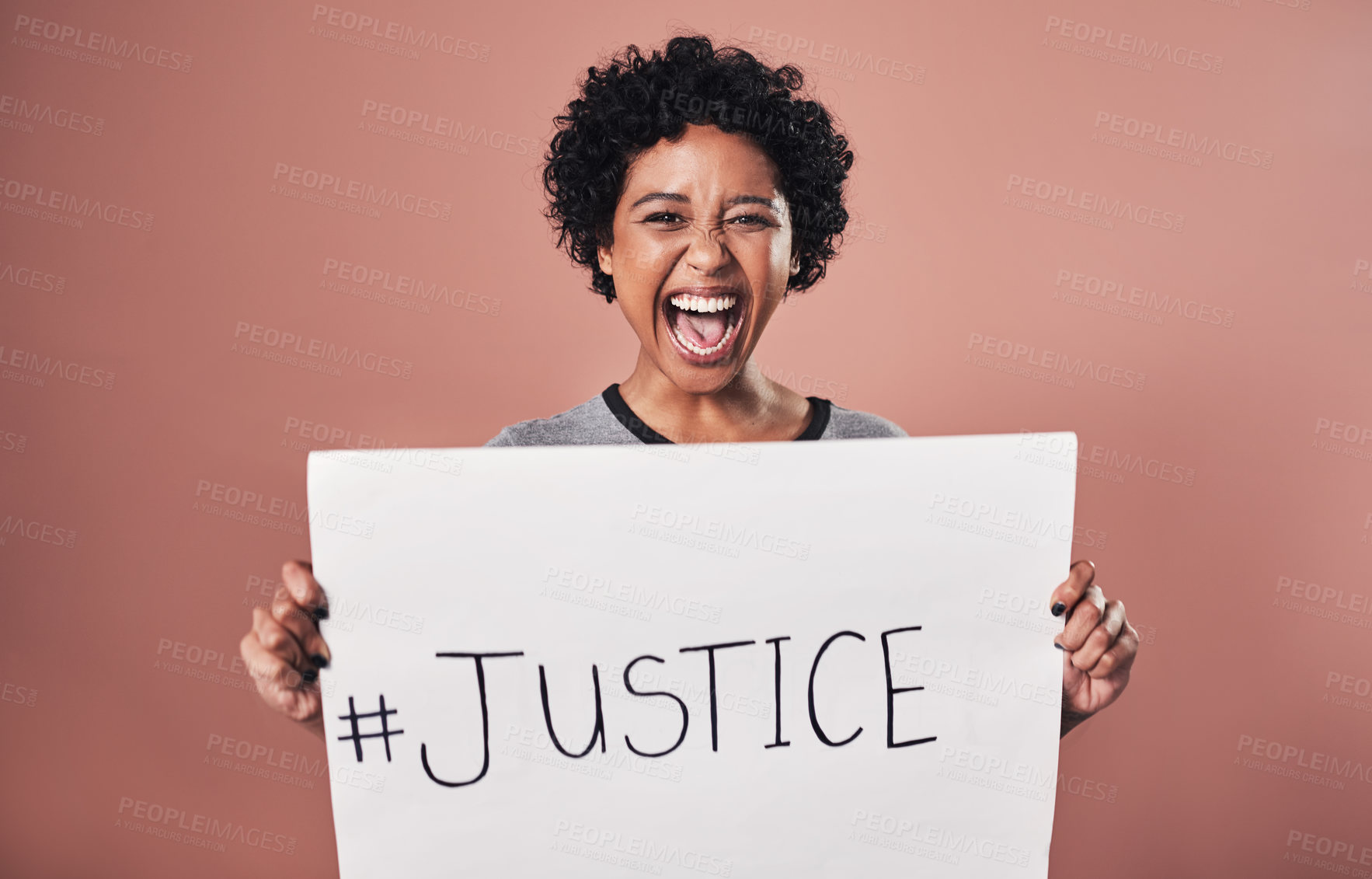 Buy stock photo Studio shot of a young woman holding up a poster reading 