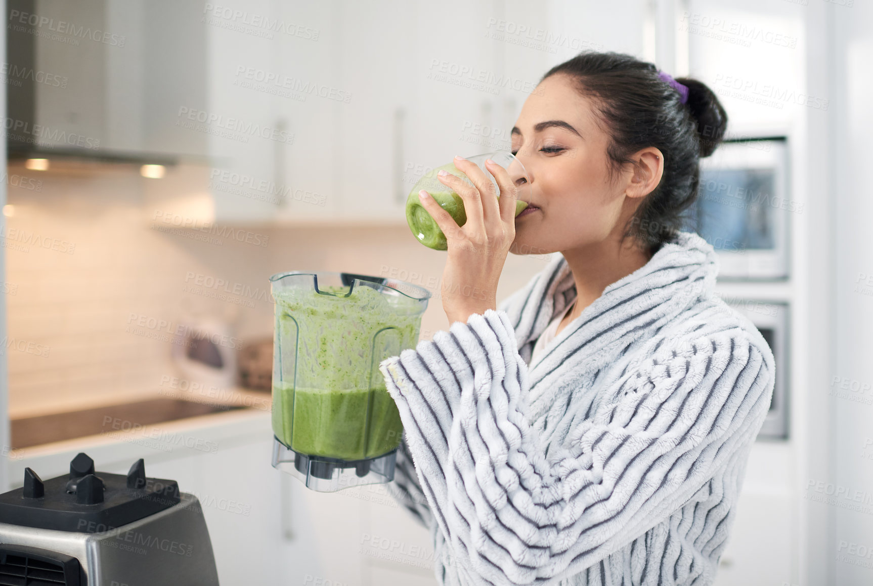 Buy stock photo Cropped shot of a woman drinking a smoothie at home