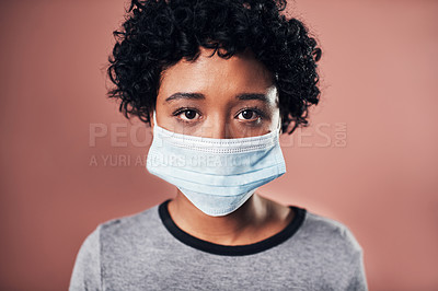 Buy stock photo Studio shot of a young wman wearing a mask against a pink background