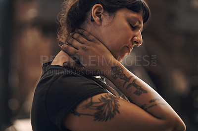 Buy stock photo Shot of a young woman experiencing neck pain while working at a foundry