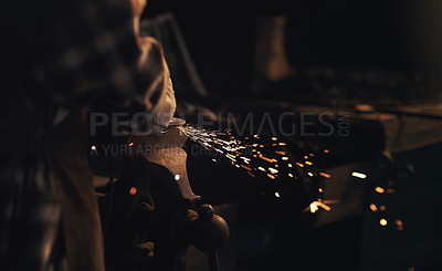 Buy stock photo Shot of a blacksmith using an angle grinder while working at a foundry