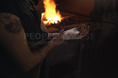 Buy stock photo Shot of a woman working at a foundry with a bandage wrapped around her hand