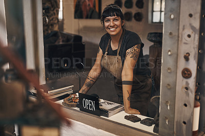 Buy stock photo Portrait of a young woman standing at the front desk with an open sign of a foundry