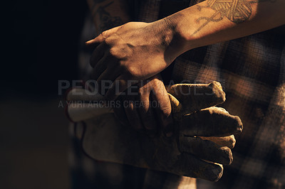 Buy stock photo Cropped shot of an unrecognisable holding a pair of gloves while working at a foundry