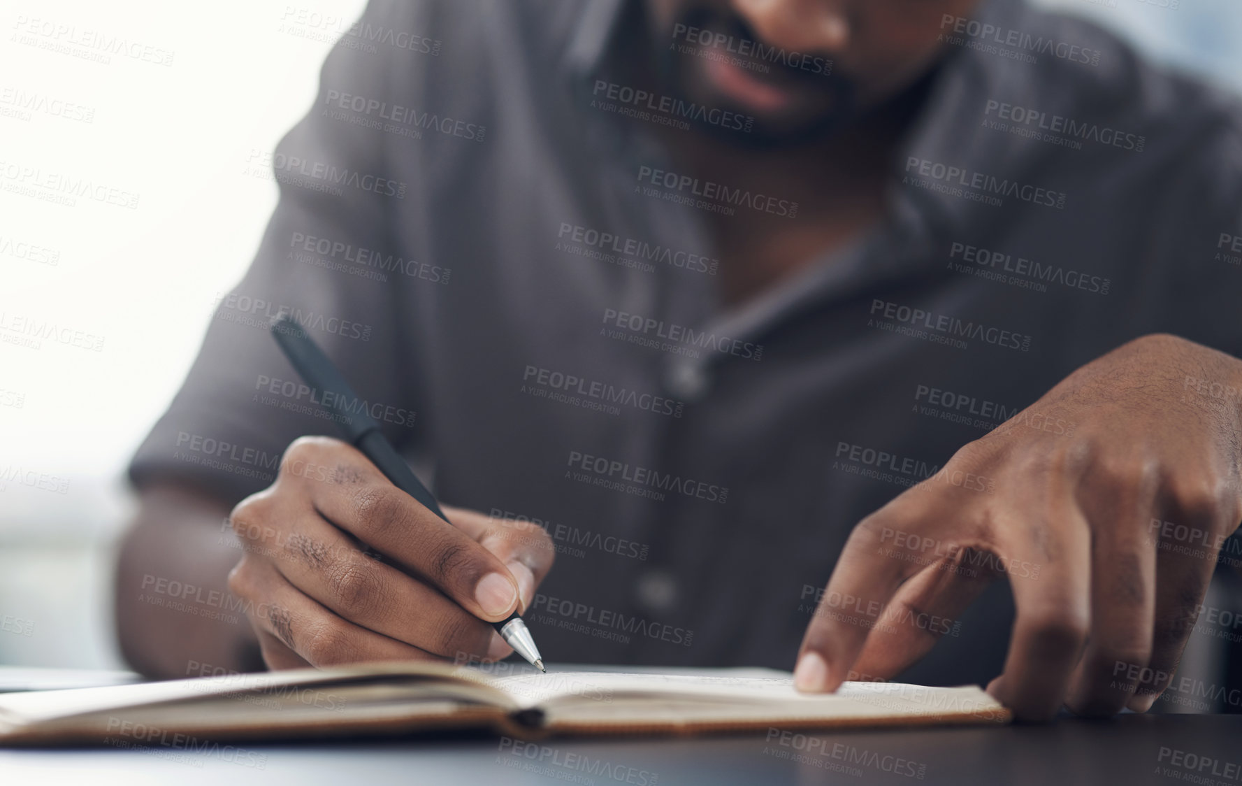 Buy stock photo Closeup shot of an unrecognisable businessman writing in a notebook in an office