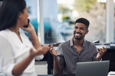 Buy stock photo Shot of a young businessman shrugging at a colleague who is talking on a cellphone in an office