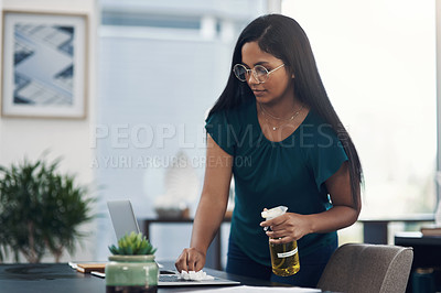 Buy stock photo Shot of a young businesswoman cleaning a laptop in an office