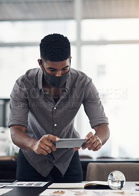 Buy stock photo Shot of a young designer taking photos of his work in an office
