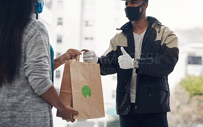 Buy stock photo Shot of a masked young man showing thumbs up while delivery takeout to a customer at home