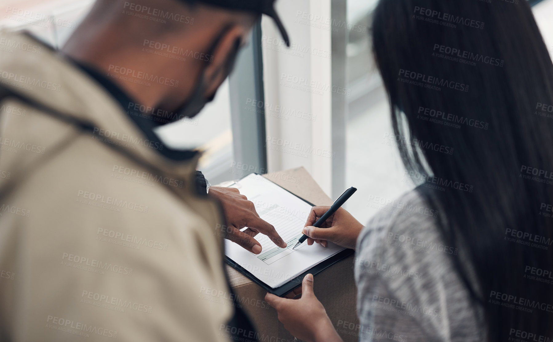 Buy stock photo Cropped shot of a woman signing for a delivery received at home