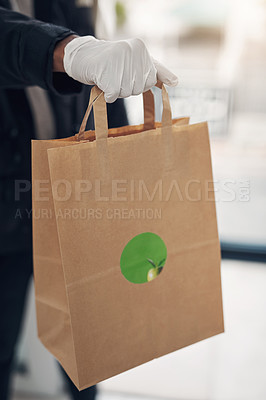 Buy stock photo Shot of an unrecognisable gloved man delivering takeout to a place of residence