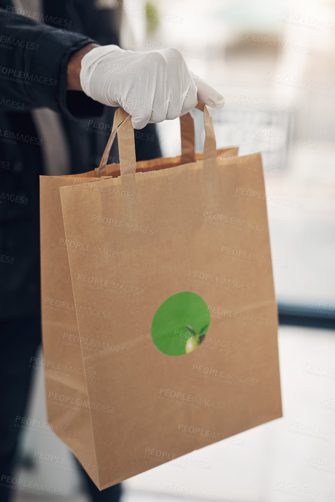 Buy stock photo Shot of an unrecognisable gloved man delivering takeout to a place of residence