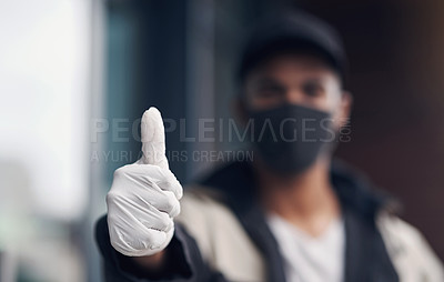 Buy stock photo Shot of a masked young man showing thumbs while making a home delivery